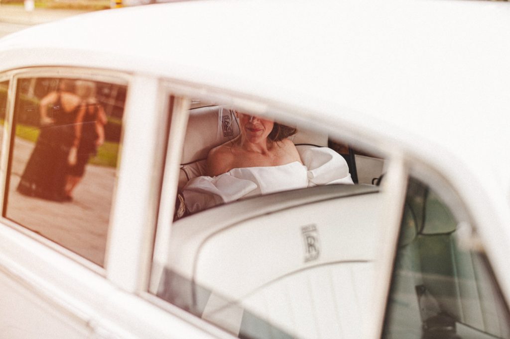 Santa Monica classy bride photographed through car window before her wedding at St. Monicas Catholic Church