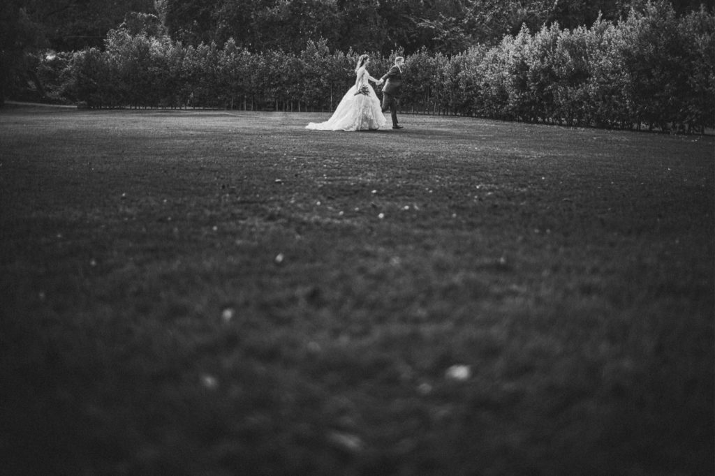 creative wedding photos at Calamigos Ranch wedding black and white photo of couple in distance walking 