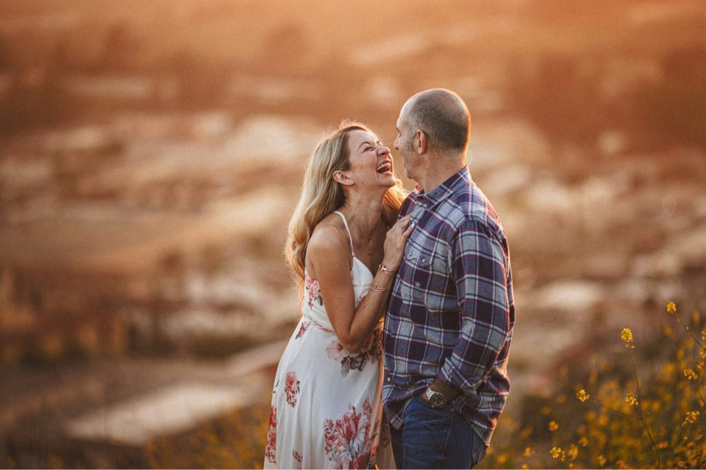 Ventura Engagement session with the city in the background at sunset with couple laughing 