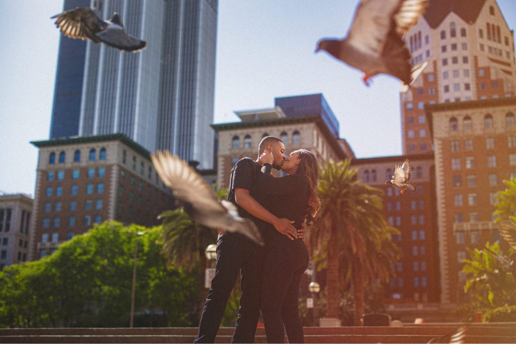 Pershing Square engagement session in down town LA of couple kissing and birds flying around them