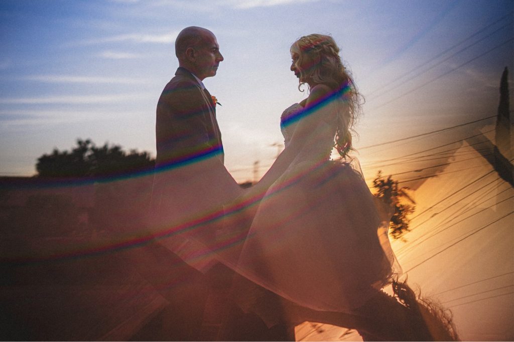 Wedding Couples creative portrait with reflection at bottom of the sunset colors 