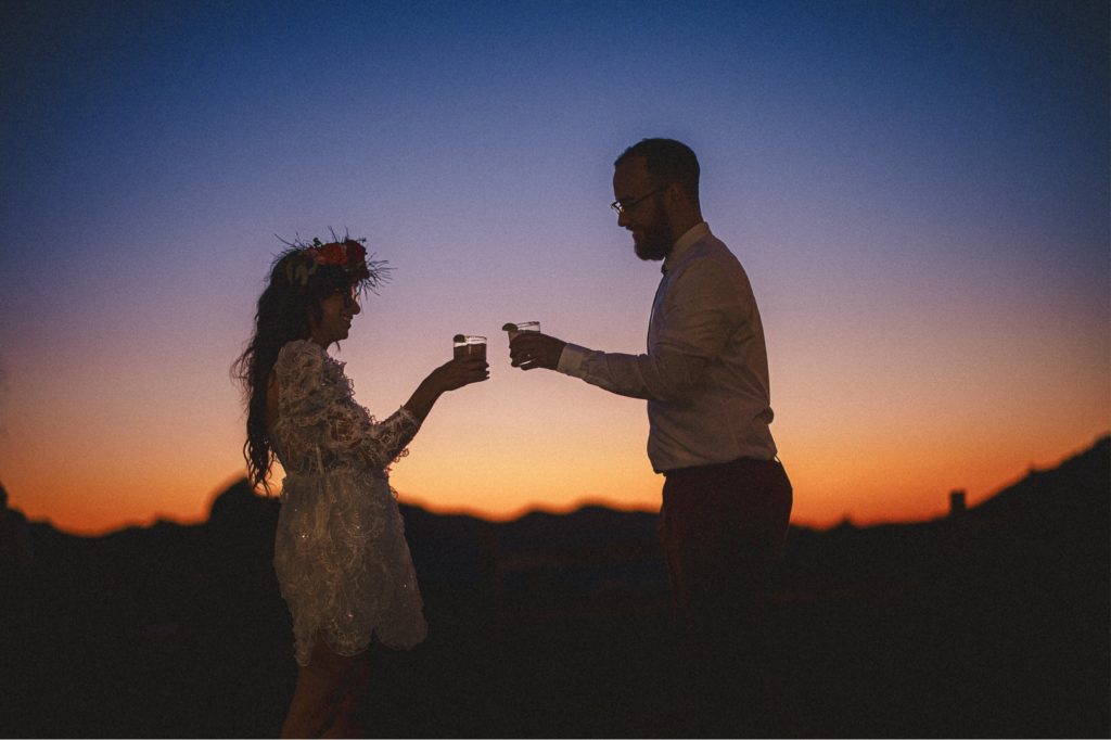 Cielo farm Malibu wedding with couples sharing a cheers with their drinks at sunset with the mountains in the background