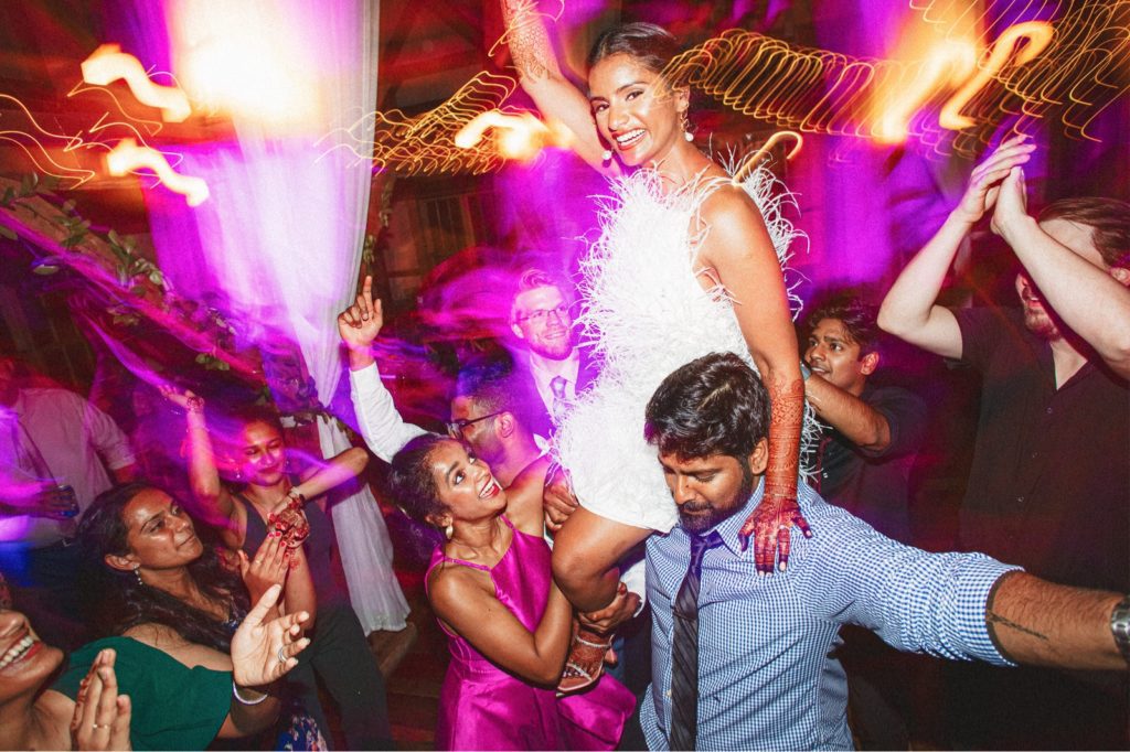 Valley View Farm wedding where the bride is on the guests shoulders at her reception with lights and colors swirling around her