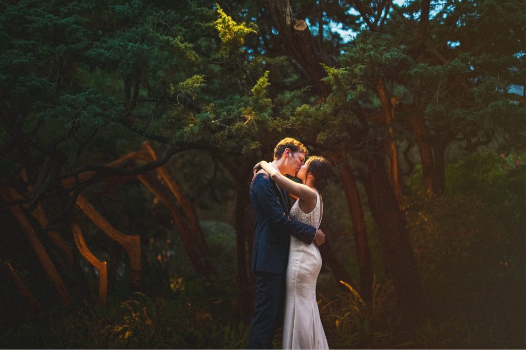 Dark and moody wedding portrait of couple kissing at their wedding Montecito California
