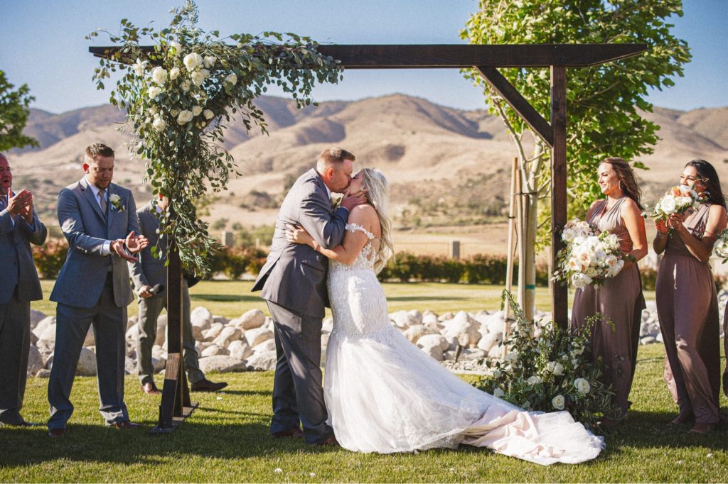 Leona Valley wedding ceremony with the mountains in the background and the couple having their first kiss as a married couple
