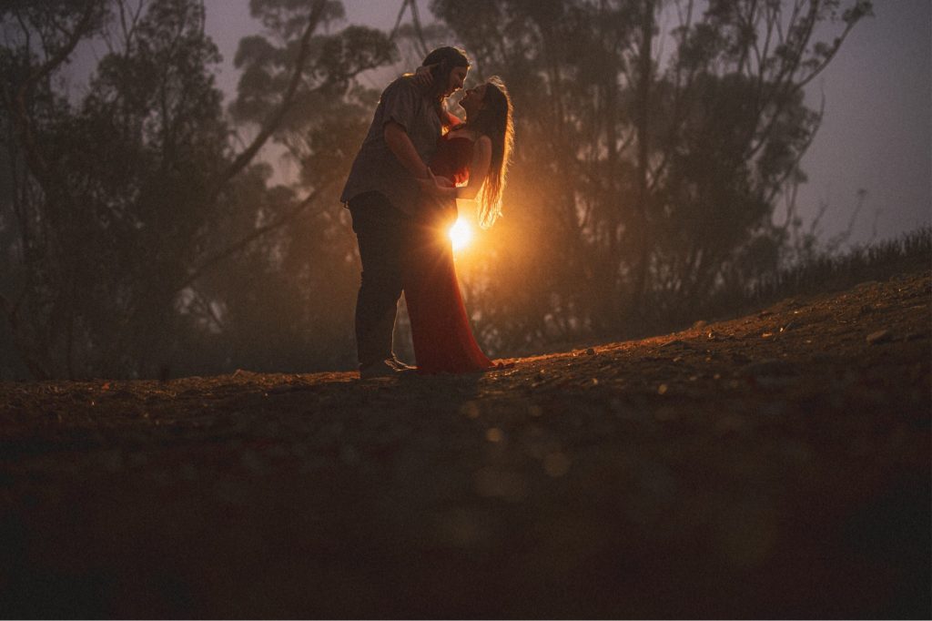 dark and moody Ventura engagement session with warm light coming from behind couple creating a romantic feel 