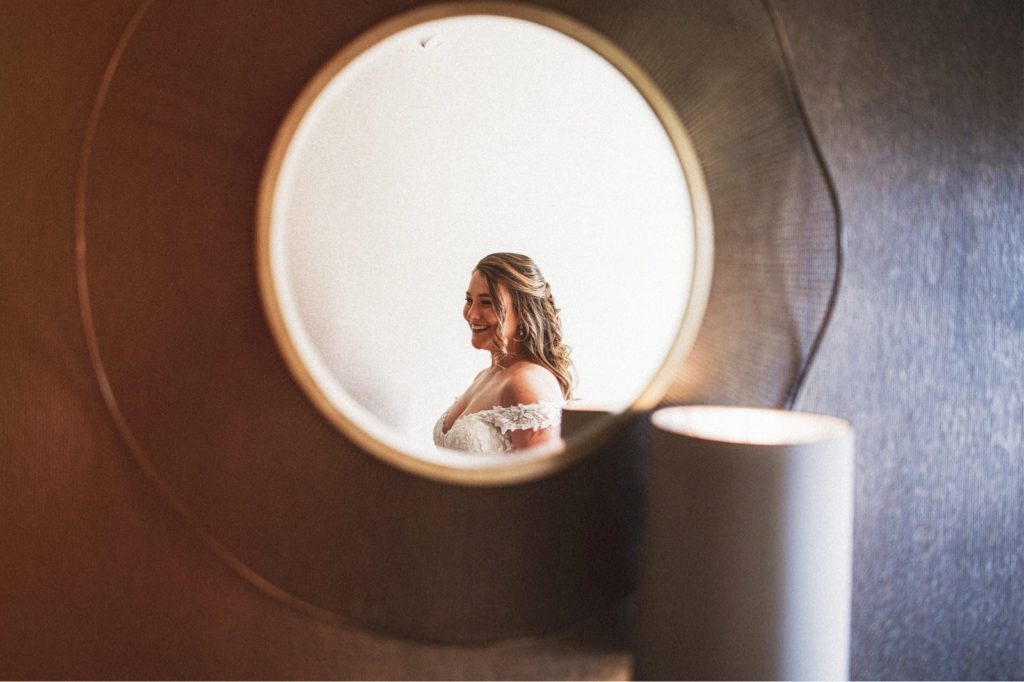 Bride through the mirror as she gets ready for her butterfly preserve wedding in Goleta California
