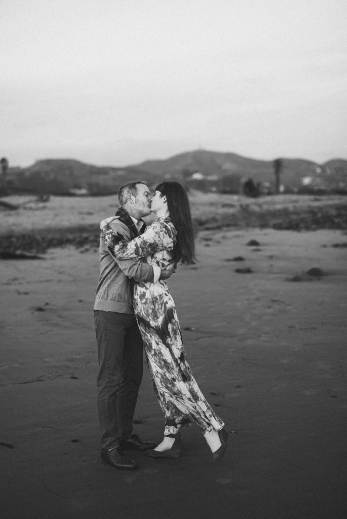The bride and groom kissing on the beach in Ventura California in a very classic Black and white photo